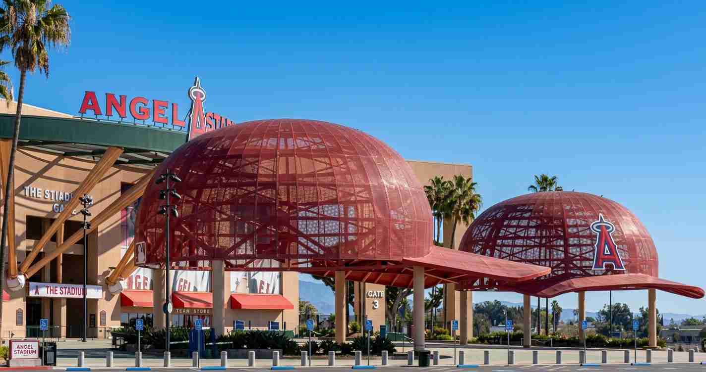 Angels Stadium in Anaheim with two red geodesic dome structures and a clear blue sky behind them.