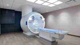 MRI machine in a clinical room with a sliding patient table ready for scanning.10