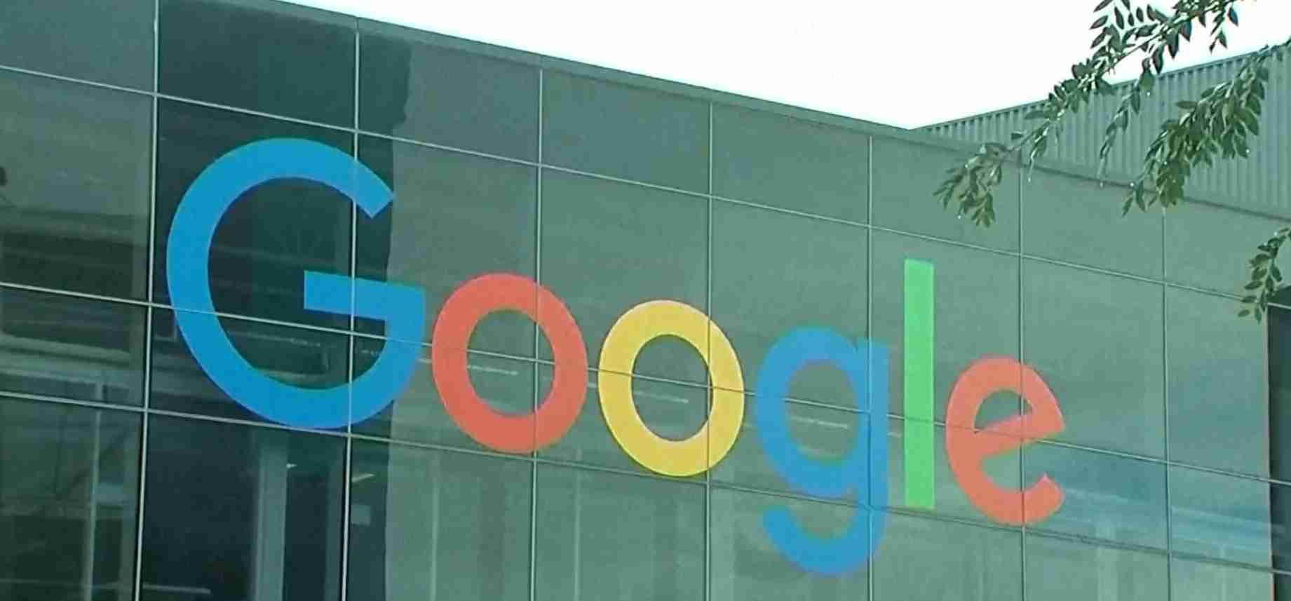 Exterior view of a glass building with the colorful Google logo displayed on the facade.