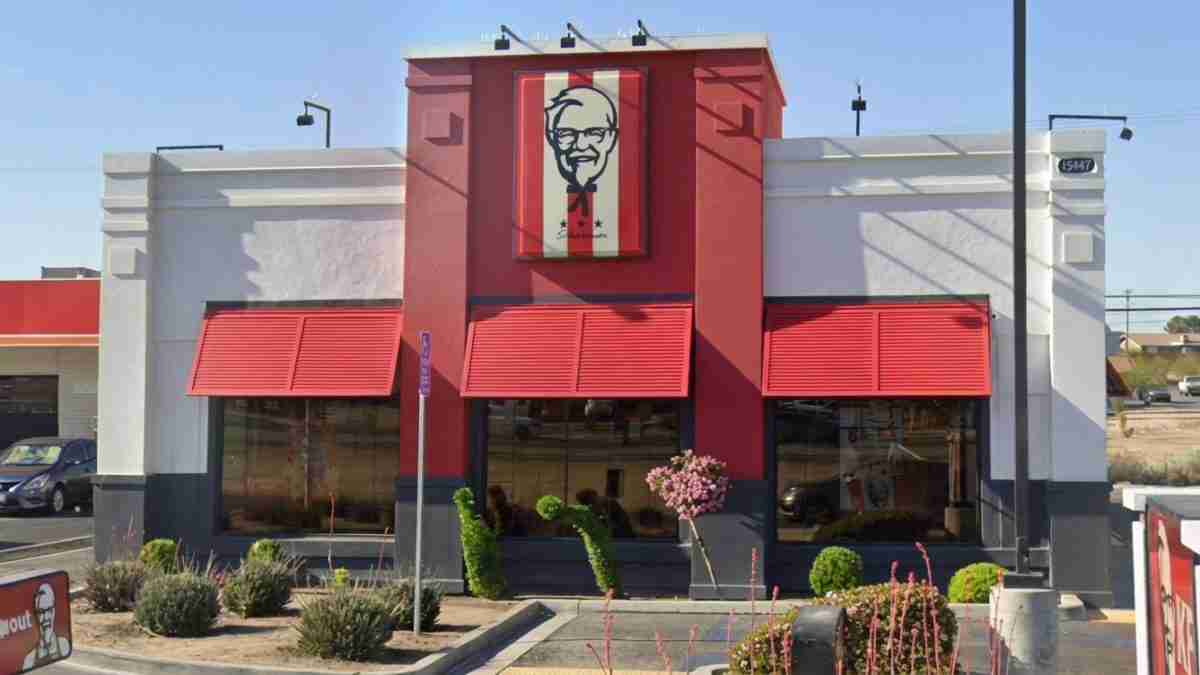 Exterior of a KFC restaurant: red facade, two large red awnings over the windows, and a Colonel Sanders sign above the entrance.